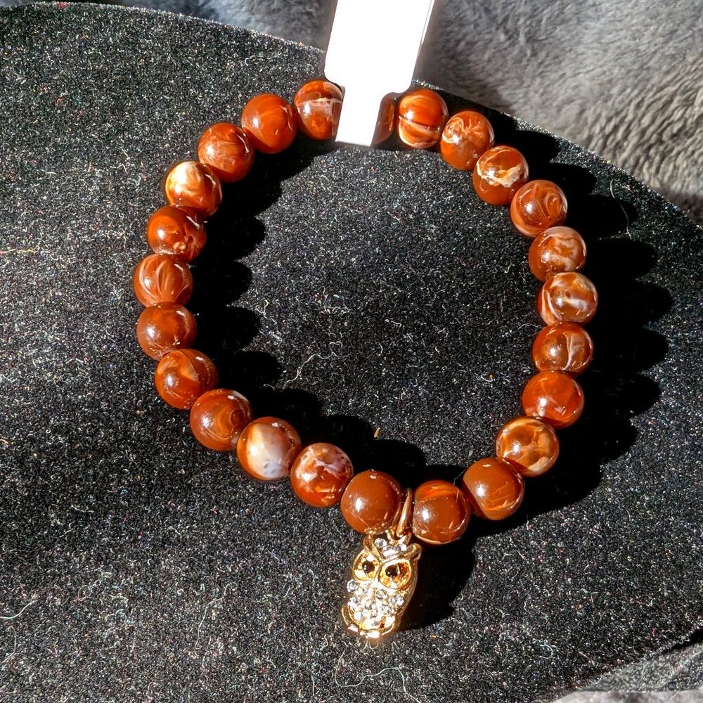 Gold and silver tone Gemmed owl rides on brown swirled beaded bracelet #37